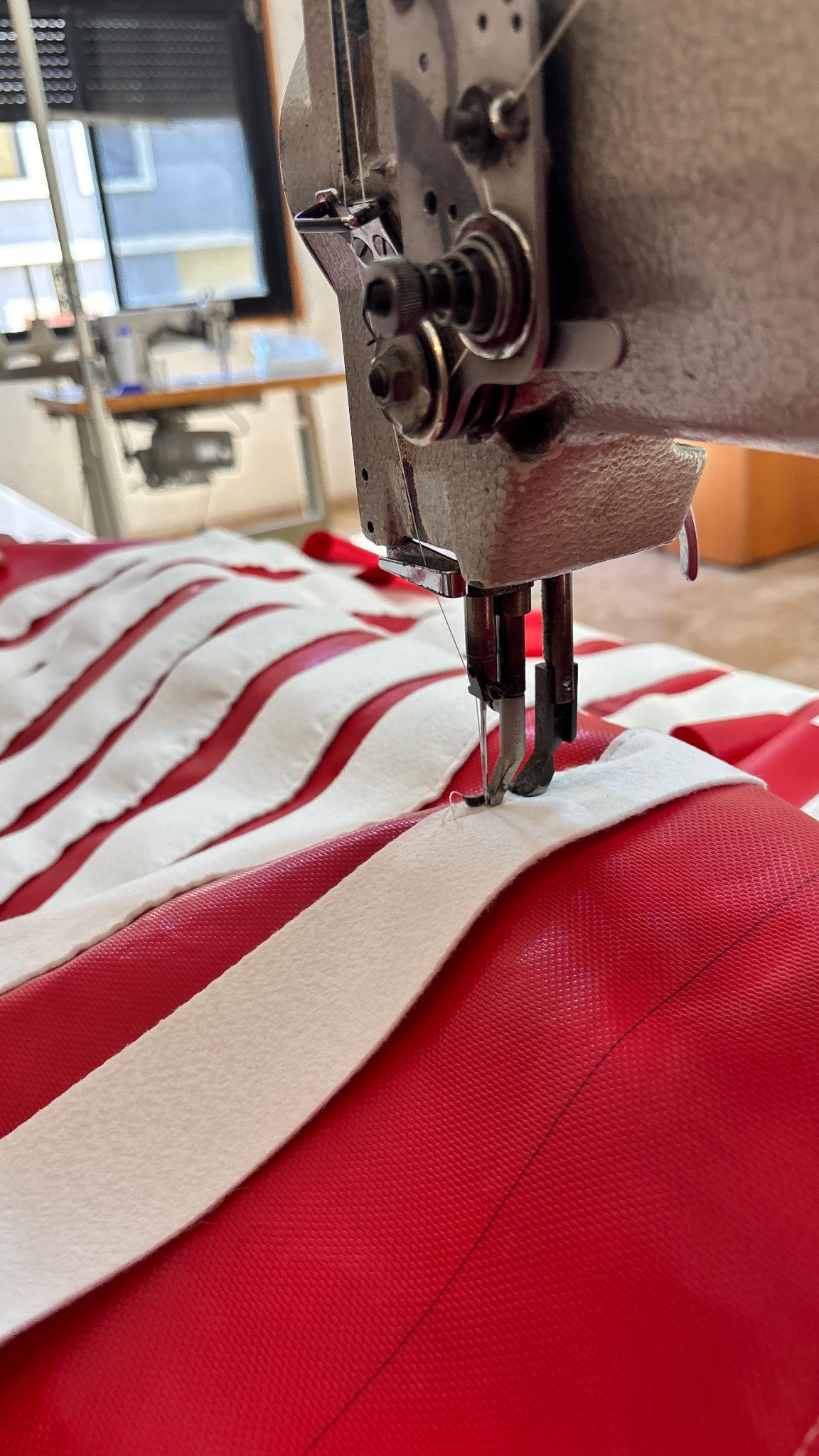 Red mesh and fabric being stitched for filter accessories